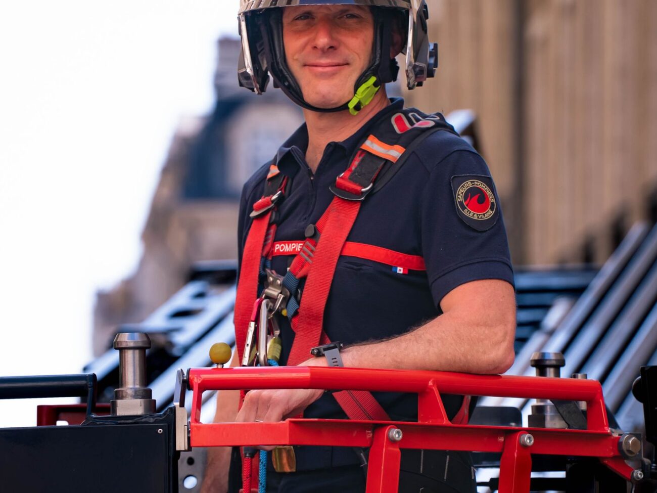 Sapeur-pompier en intervention sur l'échelle d'un engin de secours